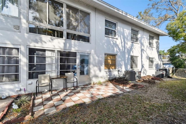 back of property featuring a patio area, cooling unit, and stucco siding