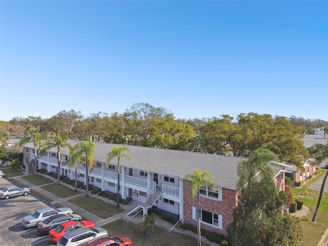 view of building exterior with uncovered parking and a residential view