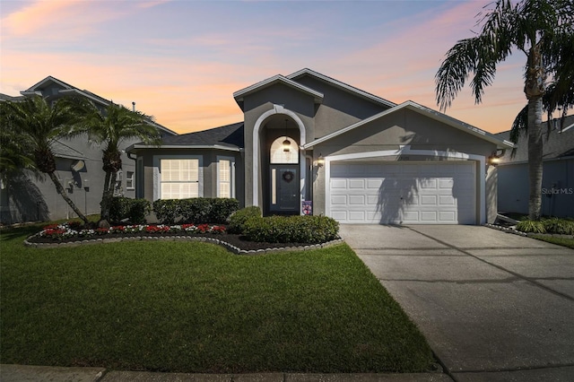 single story home featuring a garage, stucco siding, driveway, and a yard