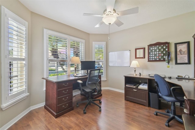 office featuring wood finished floors, baseboards, and ceiling fan