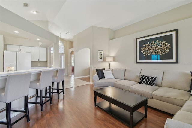 living area with visible vents, baseboards, dark wood finished floors, recessed lighting, and arched walkways