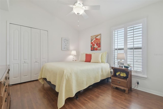 bedroom with a ceiling fan, wood finished floors, a closet, baseboards, and vaulted ceiling