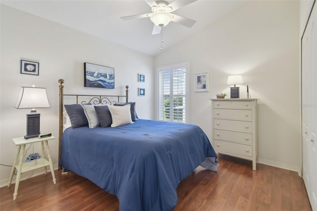 bedroom featuring baseboards, lofted ceiling, wood finished floors, and a ceiling fan