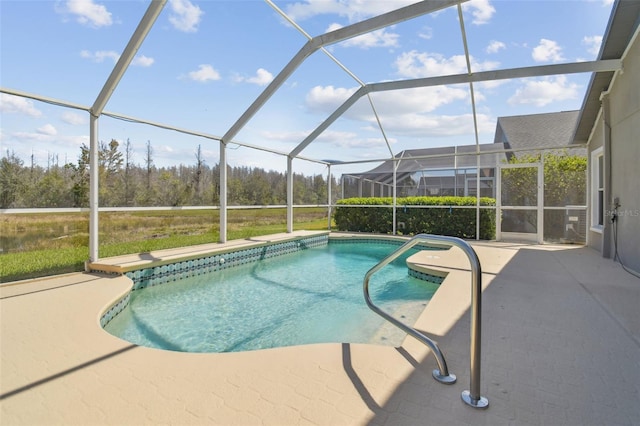 outdoor pool featuring glass enclosure and a patio