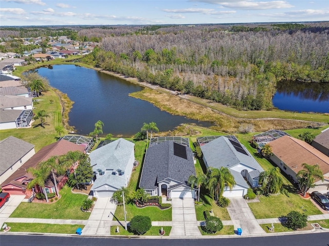 aerial view featuring a forest view, a residential view, and a water view