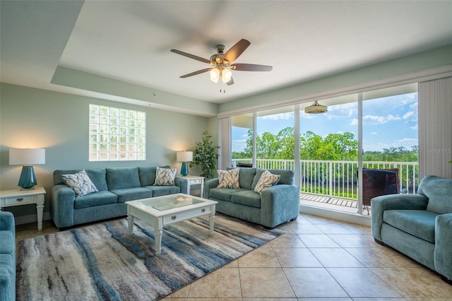 living area with a ceiling fan and tile patterned floors