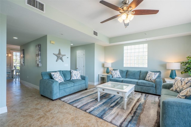 tiled living area with a ceiling fan, visible vents, and baseboards