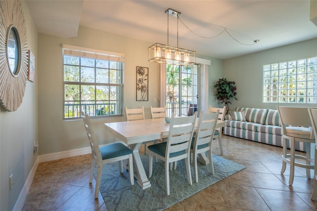 dining area featuring plenty of natural light, tile patterned flooring, and baseboards