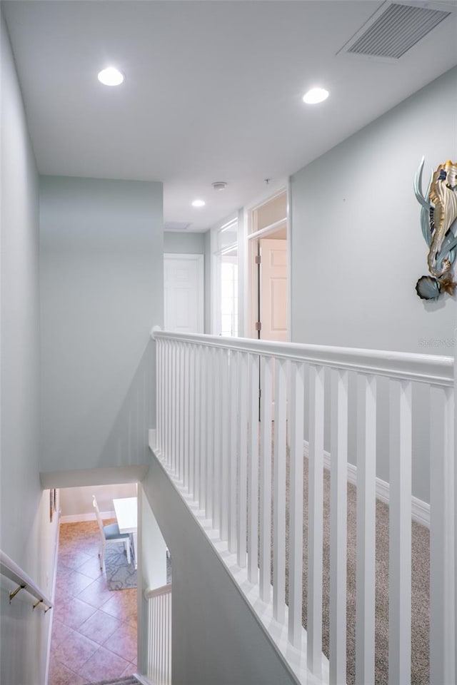 corridor with recessed lighting, visible vents, baseboards, and tile patterned floors