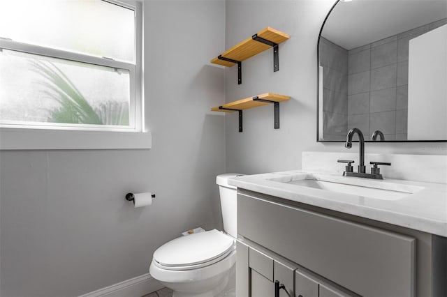 bathroom featuring vanity, toilet, and baseboards