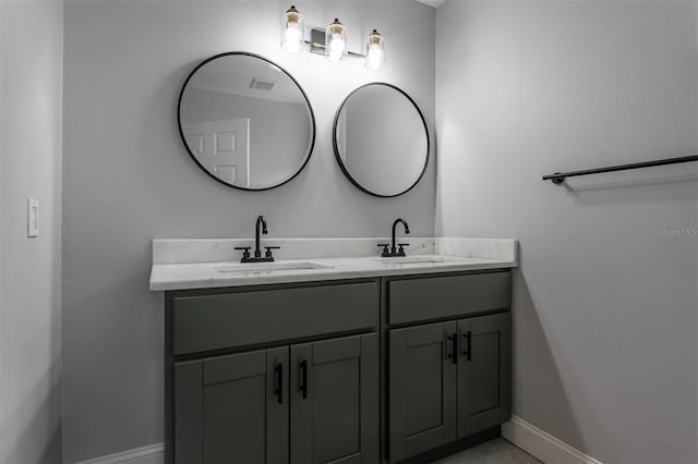 full bathroom featuring a sink, baseboards, and double vanity