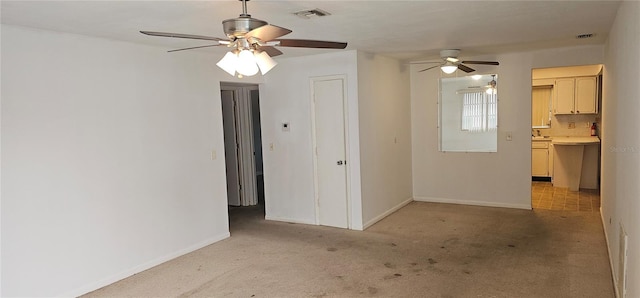 empty room featuring light carpet, baseboards, and visible vents