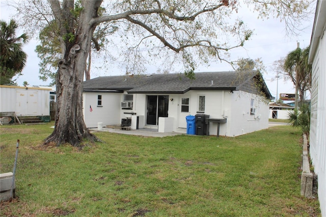 rear view of property featuring an outbuilding, a yard, a shed, and a patio