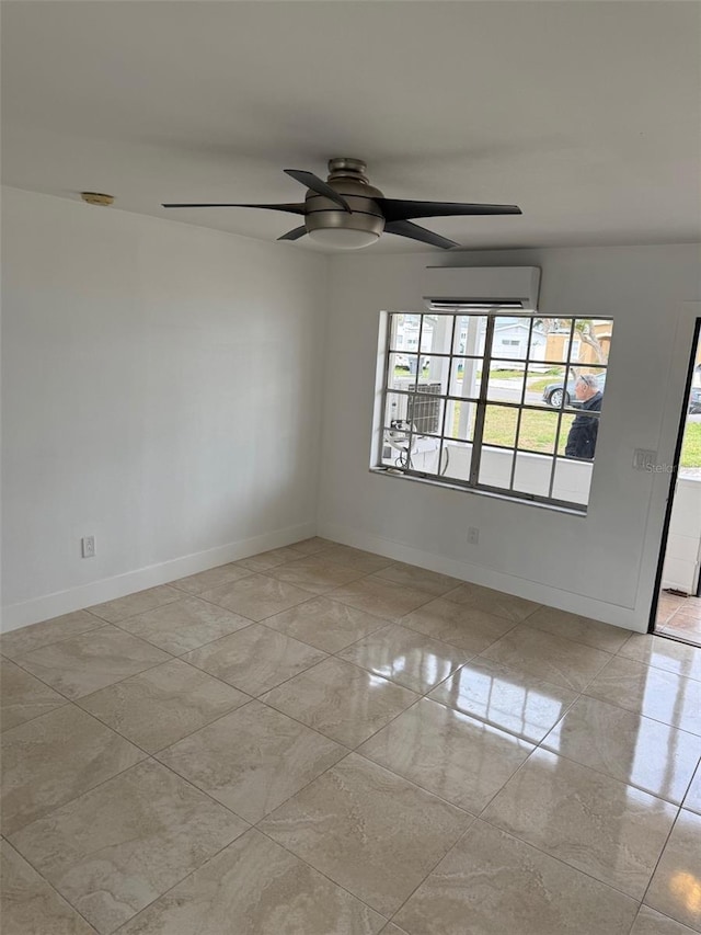 empty room with a ceiling fan, a wall unit AC, plenty of natural light, and baseboards