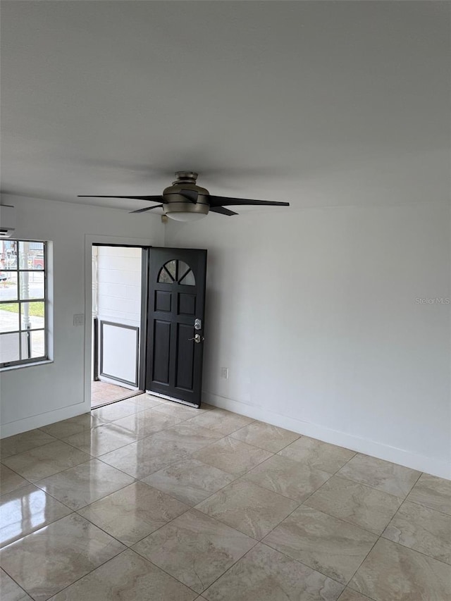 empty room with ceiling fan and baseboards