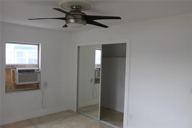 unfurnished bedroom with ceiling fan, multiple windows, a closet, and baseboards