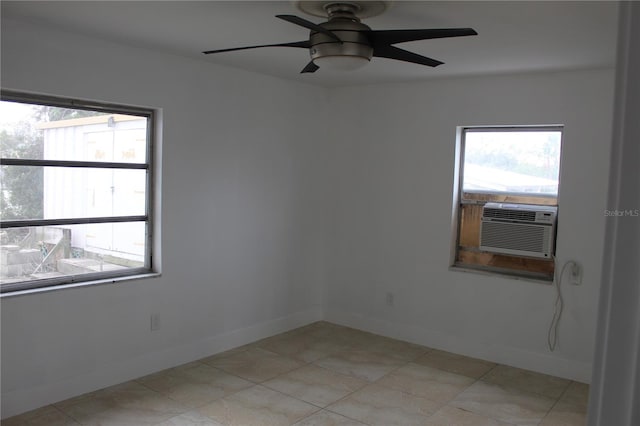 empty room featuring cooling unit, ceiling fan, and baseboards