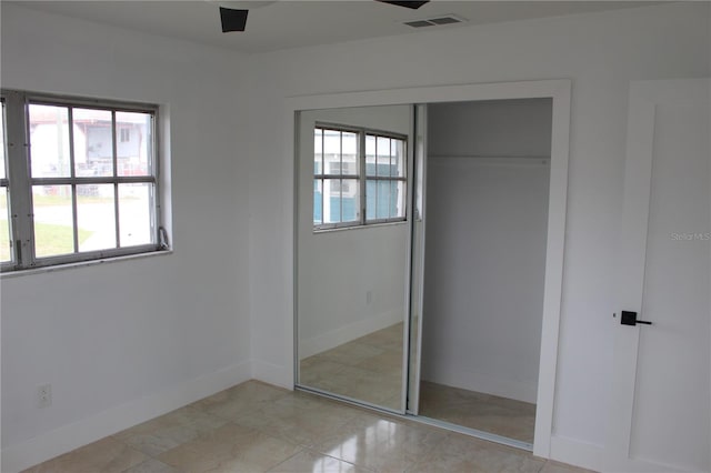 unfurnished bedroom featuring a closet, visible vents, and baseboards