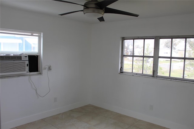 spare room featuring a ceiling fan, cooling unit, a wealth of natural light, and baseboards