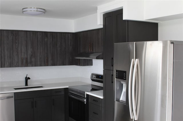 kitchen featuring decorative backsplash, stainless steel appliances, light countertops, under cabinet range hood, and a sink