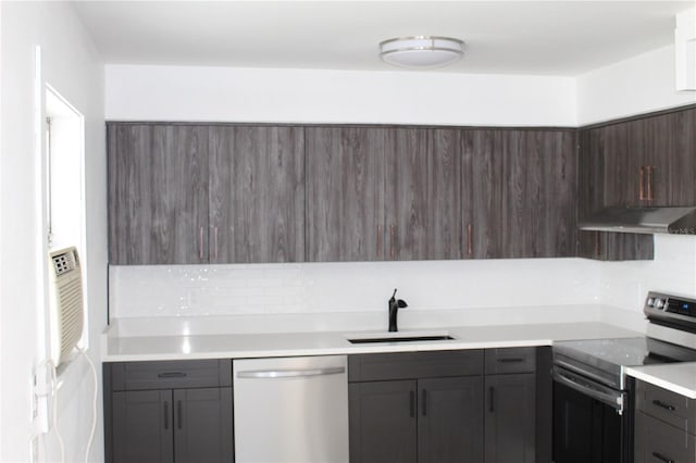 kitchen with stainless steel appliances, light countertops, a sink, and under cabinet range hood