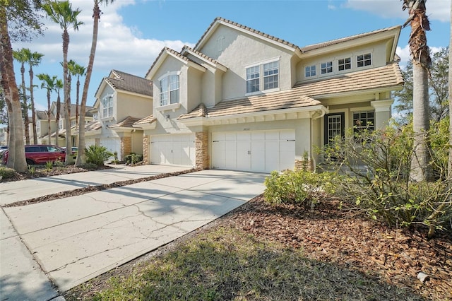 view of front of home featuring driveway, a tile roof, a garage, and stucco siding