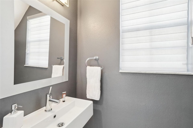 bathroom featuring a textured wall and a sink