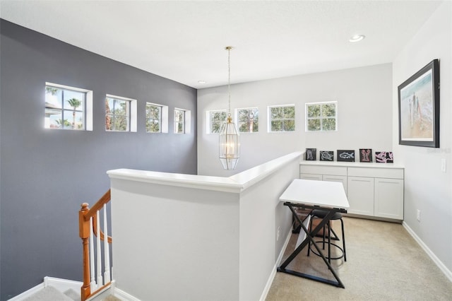 corridor with light carpet, baseboards, an upstairs landing, a notable chandelier, and recessed lighting