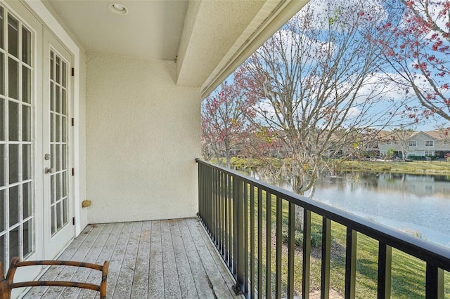 balcony featuring french doors and a water view