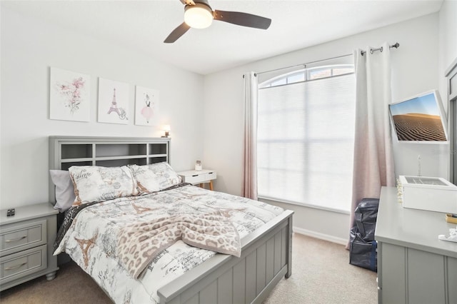 bedroom with light carpet, ceiling fan, and baseboards