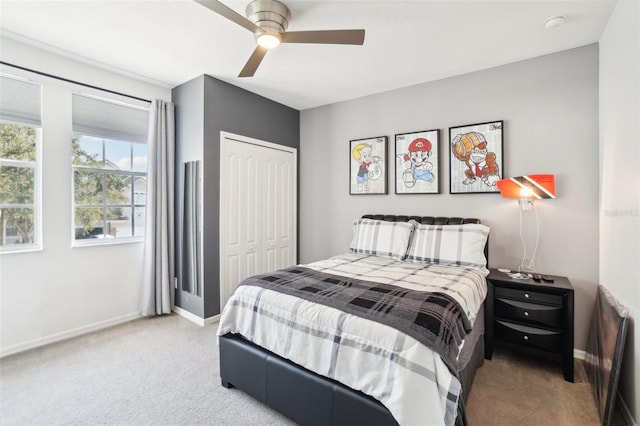 carpeted bedroom with a ceiling fan, baseboards, and a closet