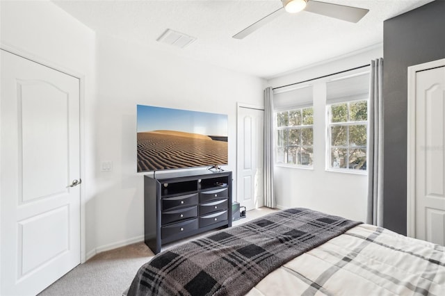 carpeted bedroom with baseboards, visible vents, and ceiling fan