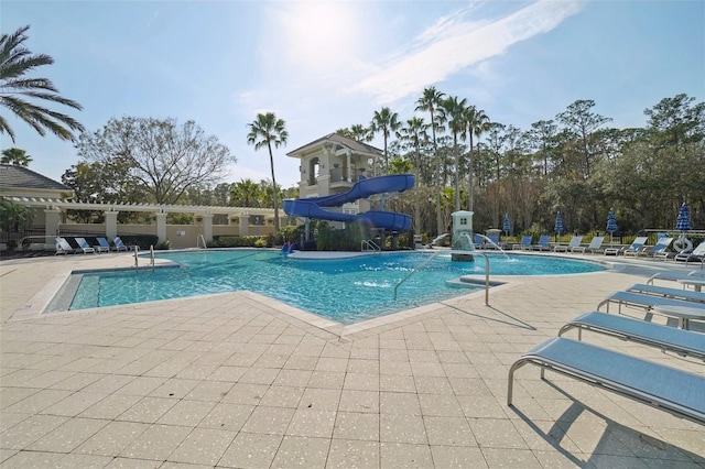 community pool featuring a water slide and a patio area