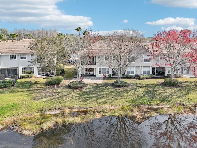 view of front of house with a front yard and a water view