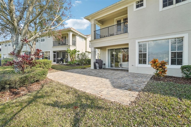 rear view of house featuring a patio area and stucco siding