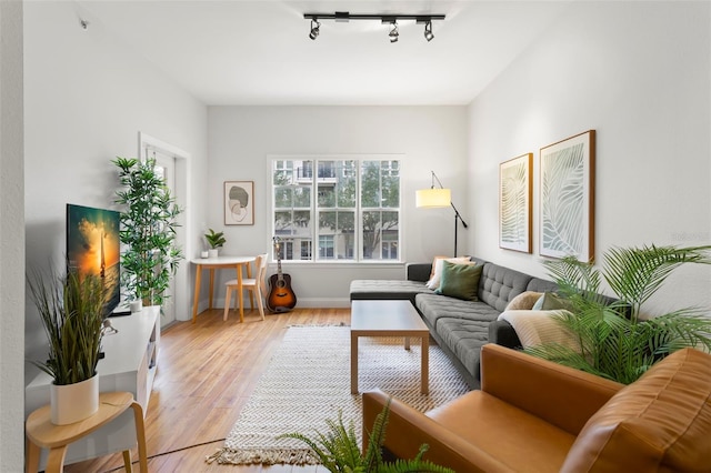 interior space with light wood-style floors, baseboards, and track lighting