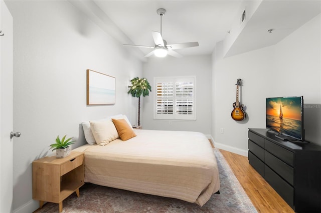 bedroom with visible vents, baseboards, ceiling fan, and wood finished floors