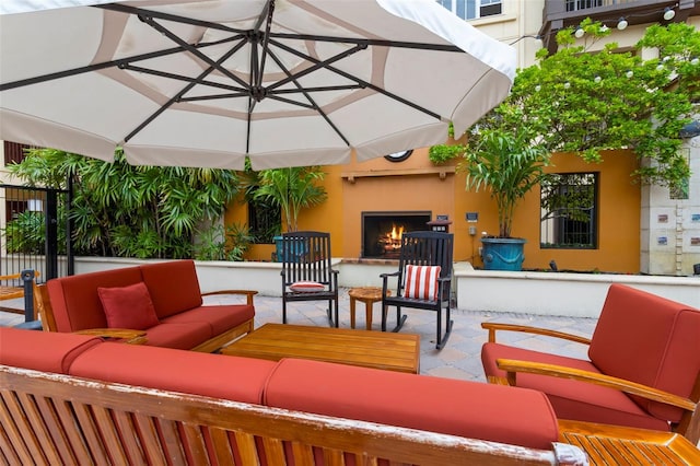 view of patio with an outdoor living space with a fireplace