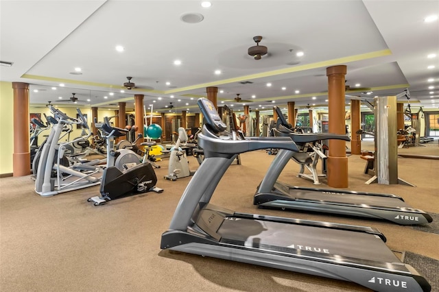 gym featuring ornate columns, visible vents, a raised ceiling, and recessed lighting