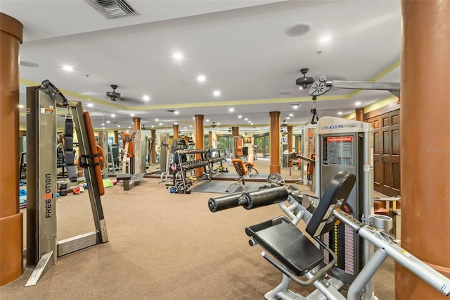 exercise room with ceiling fan, recessed lighting, visible vents, a tray ceiling, and decorative columns