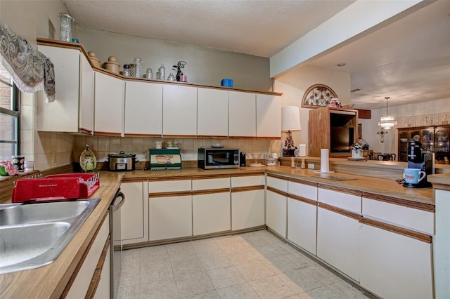 kitchen with light countertops, white cabinetry, and decorative backsplash