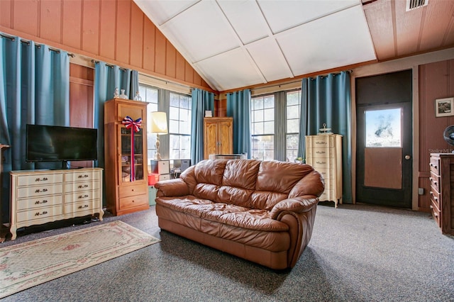 living room featuring carpet, vaulted ceiling, and wood walls