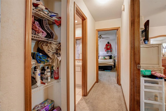 hallway with light carpet and baseboards