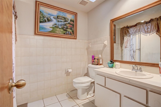 full bathroom featuring visible vents, toilet, tile patterned floors, vanity, and tile walls