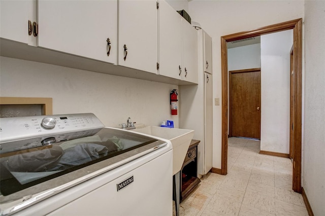 washroom with washer / dryer, baseboards, cabinet space, and light floors