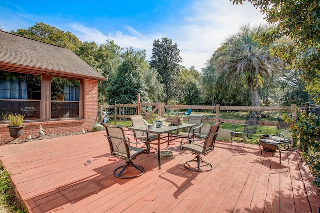 wooden deck with outdoor dining space and fence