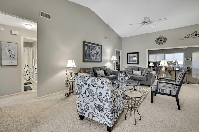 living area with light carpet, high vaulted ceiling, visible vents, and baseboards