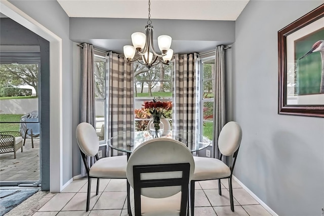 dining room with baseboards, a notable chandelier, and light tile patterned flooring