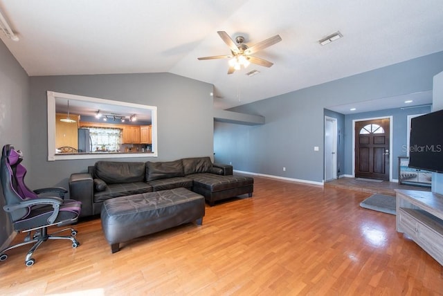 living room with lofted ceiling, light wood-style flooring, visible vents, and baseboards