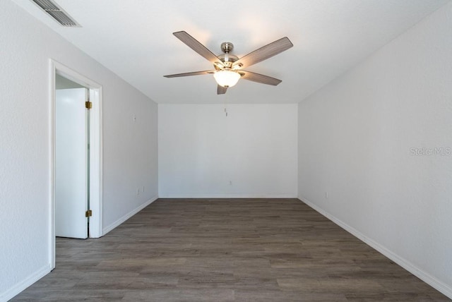 unfurnished room with dark wood finished floors, baseboards, a ceiling fan, and visible vents